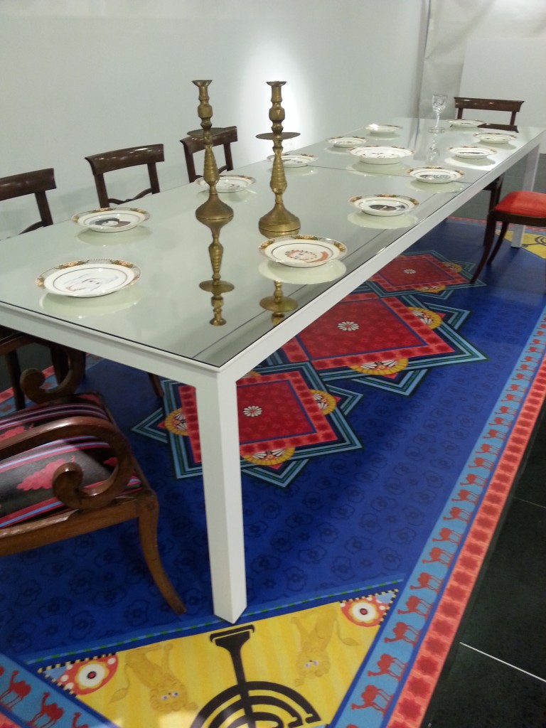 Famiglia 2013-2015print and painting on 13 porcelain plates, 6 chairs upholstered with acrylic on canvas paintings, print on linoleum carpet, metal table, mirror 450x200